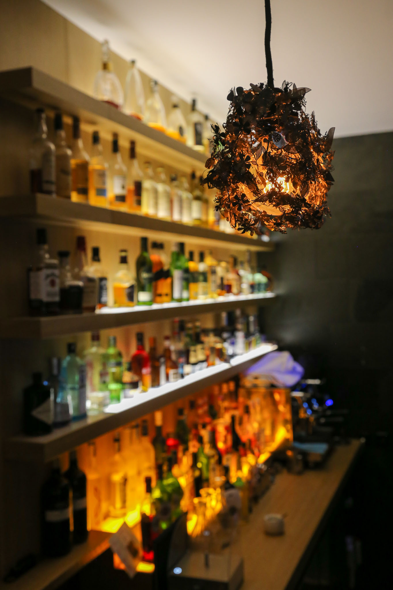 Hinter der Bar: Glitzernde Flaschen und goldener Lampenschirm #faq