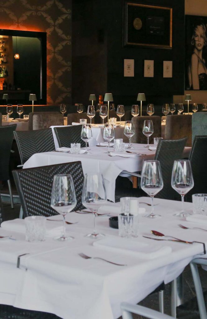 Elegantes türkisfarbenes Restaurant mit makellosen weißen Tischdecken und stilvoller Tischgedeck